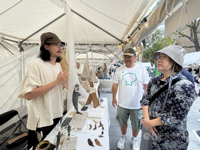 中華文化總會今年首度將TAIWAN PLUS移師大阪,以「台日新風」為主題。文化部政務次長王時思(右)9日逛市集,聆聽「鯨湯匙」創作者張意(左)解釋創作理念。中央社記者楊明珠大阪攝 114年8月9日