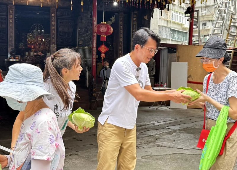 台灣民眾黨主席黃國昌(中)9日到新北市中和區北聖宮出席「民眾加菜啦!」中和場活動,發放新鮮高麗菜給到場民眾。(讀者提供)中央社記者黃旭昇新北市傳真 114年8月9日