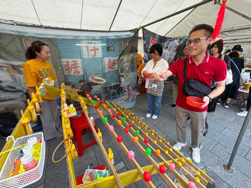 TAIWAN PLUS週末在大阪中之島公園熱鬧登場,體驗夜市經典遊戲套圈圈的人龍絡繹不絕,比想像中難控制的套圈,讓民眾驚呼聲連連。中央社記者楊明珠大阪攝 114年8月10日