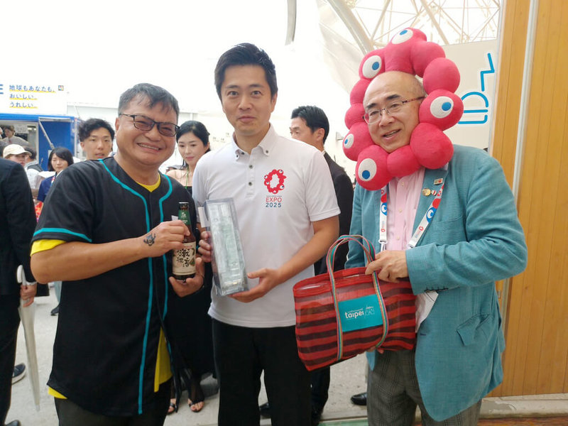 北市觀傳局10日率團登上大阪世博「大阪館」活動舞台,宣傳台北獨特的五感旅行體驗。觀傳局副局長薛秋火(左)致贈台北特色伴手禮給大阪府知事吉村洋文(中),並特別邀請他訪問台北。 (北市觀傳局提供)中央社記者戴雅真東京傳真 114年8月11日