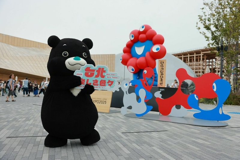 北市觀傳局10日率團登上大阪世博「大阪館」活動舞台,宣傳台北獨特的五感旅行體驗。去年大阪世博吉祥物「脈脈」曾造訪台北,與「熊讚」有一面之緣,因此這次「熊讚」特別前來與老朋友「脈脈」續情誼。 (北市觀傳局提供)中央社記者戴雅真東京傳真 114年8月11日