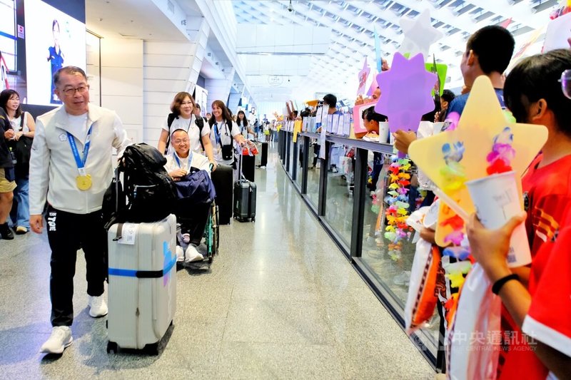 台灣女子拔河隊日前在2025成都世運會500公斤組奪金,12日載譽歸國,包含台北市景美女中、桃園市壽山高中、新北市鶯歌國中、台中市新社高中等校學生熱情接機,為學長姐獻上鮮花等致意。中央社記者吳睿騏桃園機場攝 114年8月12日