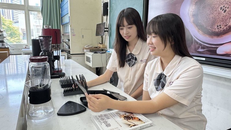 高雄市三民家商學生侯芊妘(左)、張驊軒(右)等人以所學協助屏東縣瑪家鄉咖啡產業,結合AI技術與RPG遊戲設計,開發以偏鄉咖啡為主題的遊戲「勇者與魔豆的試煉」,獲高中生AI扎根系列活動「特別表現獎」。(三民家商提供)中央社記者林巧璉傳真 114年8月12日
