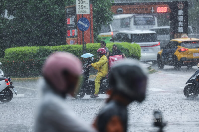 台北市中正區機車騎士全副武裝在雨中疾行。（中央社檔案照片）