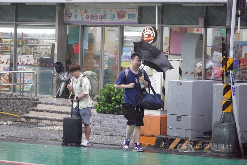 颱風楊柳進逼台灣,13日墾丁地區風雨漸強,遊客雨傘直接開花,身體也因此淋濕。中央社記者李卉婷攝 114年8月13日