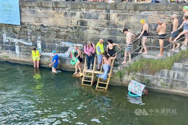 柏林市中心史普里河舉行游泳抗議活動,河上漂浮「打破游泳禁令」標語,有抗爭者穿人魚裝入水,表達想自由在城市河水中游泳的渴望。中央社記者林尚縈柏林攝 114年8月13日