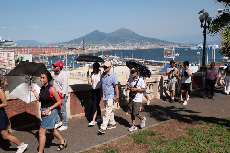 歐洲熱浪來襲，6日義大利那不勒斯遊客撐傘遮擋陽光。（安納杜魯新聞社）