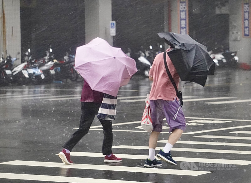 颱風楊柳撲台，高雄地區13日午後風雨明顯轉強，街頭民眾撐傘走在強風驟雨中，雨傘都被強風吹得變形。中央社記者董俊志攝　114年8月13日