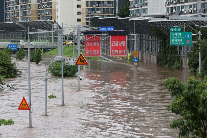 韓國首爾附近大雨，13日河川水位上漲淹沒高速公路。（韓聯社）