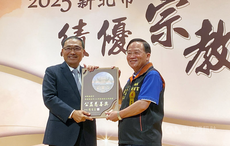 2025新北市績優宗教團體表揚大會14日在市府舉行，其中有67家宗教團體榮獲「公益慈善」類獎項，市長侯友宜（左）出席，親自頒獎給板橋埔墘福德宮主委廖榮清（右）。中央社記者黃旭昇新北市攝　114年8月14日