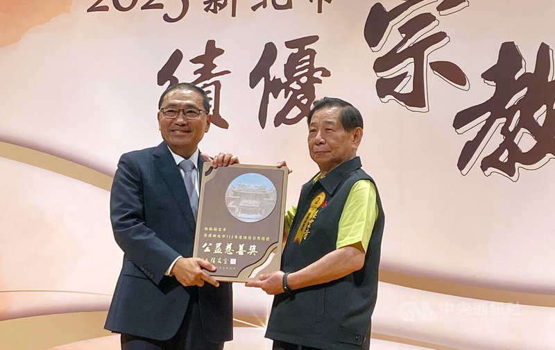 新北市政府14日表揚125家熱心公益、服務社會的績優宗教團體,其中板橋接雲寺榮獲「公益慈善」類獎項,主委江清秀(右)從市長侯友宜(左)手中接下獎牌。中央社記者黃旭昇新北市攝 114年8月14日