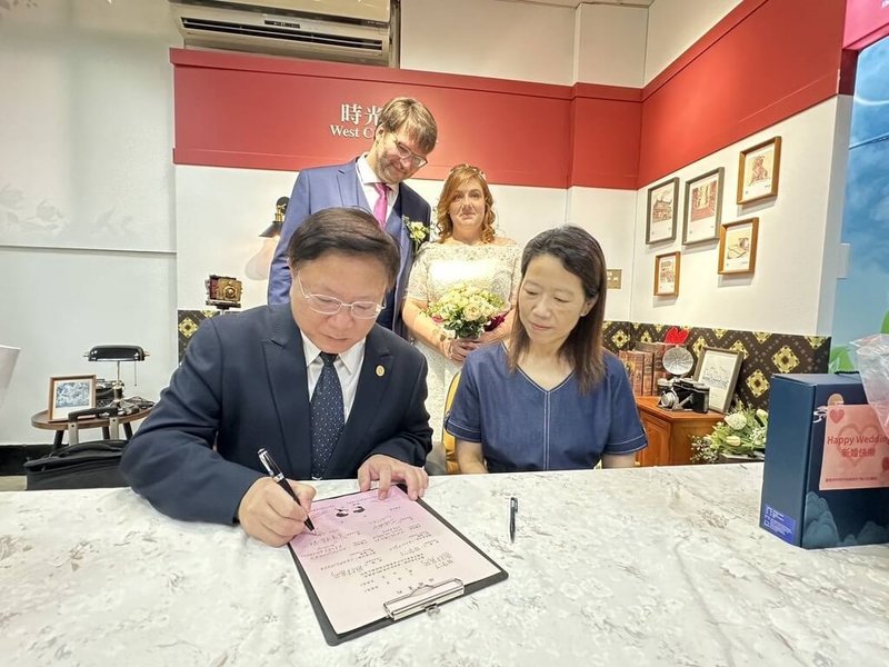 一對德國新人Martin與Greta(後排)14日在台南登記結婚,觀光署雲嘉南國家風景區管理處處長徐振能(前排左)與台南市觀光旅遊局專門委員丁伶俐(前排右)作其見證人。(觀光署法蘭克福辦事處提供)中央社記者林尚縈柏林傳真 114年8月15日