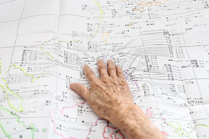 高齡96歲的台籍日本兵周良仁對80年前的事仍記憶猶新,他攤開一張「太平洋戰爭日本海軍艦船喪失一覽圖」如數家珍。中央社記者翁睿坤攝 114年8月15日
