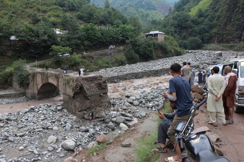 巴基斯坦季風豪雨在北部各地引爆突發性洪水而導致災難。巴控克什米爾地區首府穆薩法拉巴德居民15日聚集在一座受損橋樑旁。(路透社)