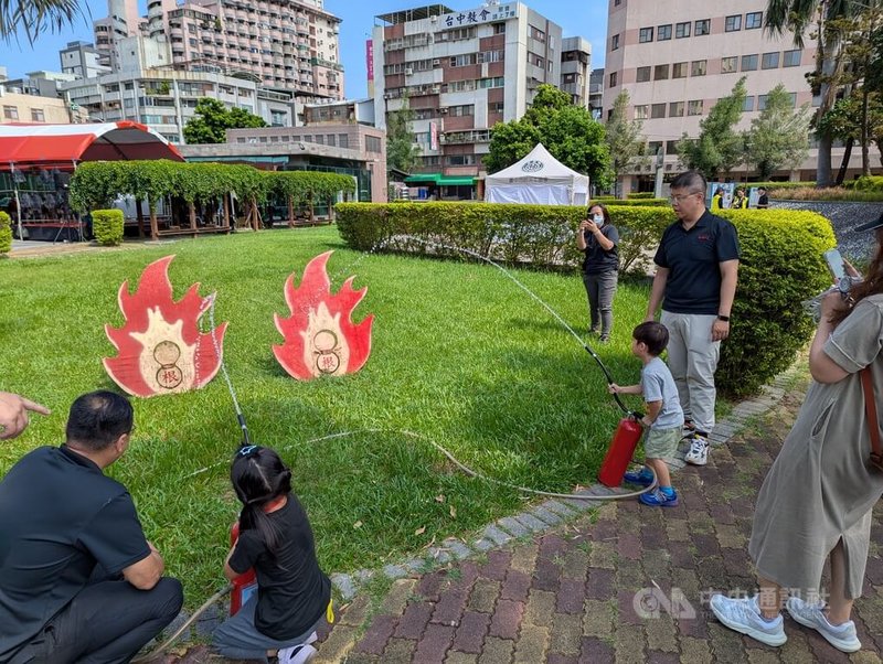 中國醫藥大學附設醫院17日與台中市消防局、台灣防災士協會等單位共同舉辦「防災韌性親子體驗營」,親子體驗滅火器等防災設施。中央社記者蘇木春攝 114年8月17日