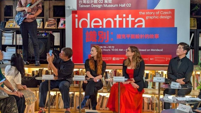 「識別–捷克平面設計的故事」展覽18日開幕式邀請爵士樂團演出,台灣設計研究院院長張基義(右起)、捷克經濟文化辦事處副代表盧貝可娃(Martina Rubeskova)、捷克中心台北主任馬凱棠(Marketa Zahumenska)、策展人布拉澤克(Filip Blazek)專注欣賞。中央社記者王寶兒攝 114年8月18日