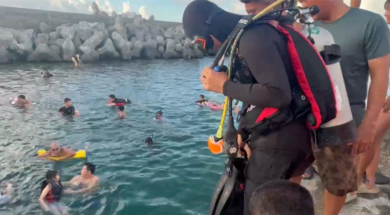 綠島中寮漁港17日傍晚，1名香港籍24歲男遊客騎乘機車不慎落海，海巡署綠島安檢所人員獲報隨即到場救援，男子自行游上岸，所幸沒有受傷，檢視港區無油污染情形。（海巡署東部分署第一三岸巡隊提供）中央社記者李先鳳傳真　114年8月18日