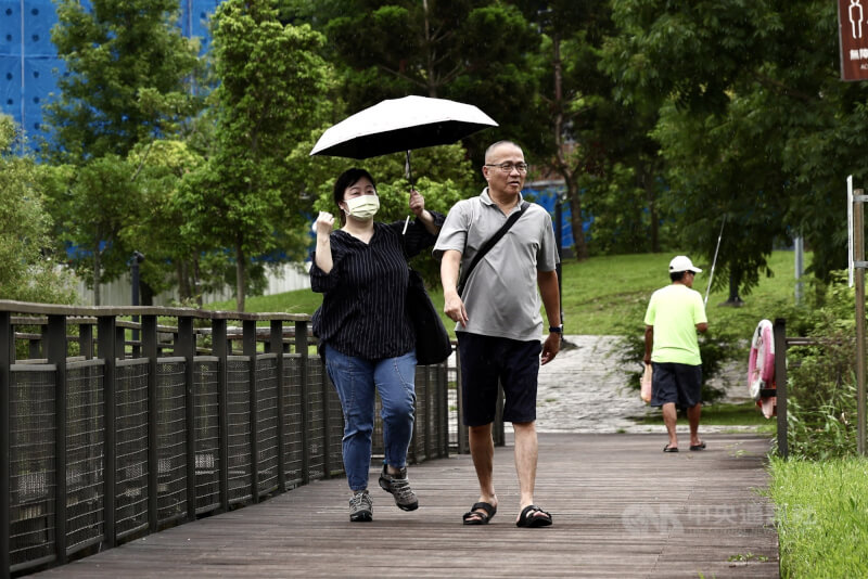 中央氣象署表示，未來一週大多是多雲到晴的天氣型態，但午後要留意雷陣雨，預估週末將會有低壓或熱帶系統為台灣帶來水氣。圖為台北市南港區下午下起小雨，民眾撐傘擋雨。（中央社檔案照片）
