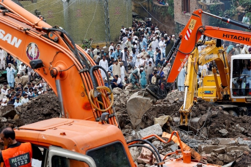 巴基斯坦持續5天的暴雨已造成近400人死亡。救難人員19日恢復搜救,居民們聚集在一旁。(路透社)