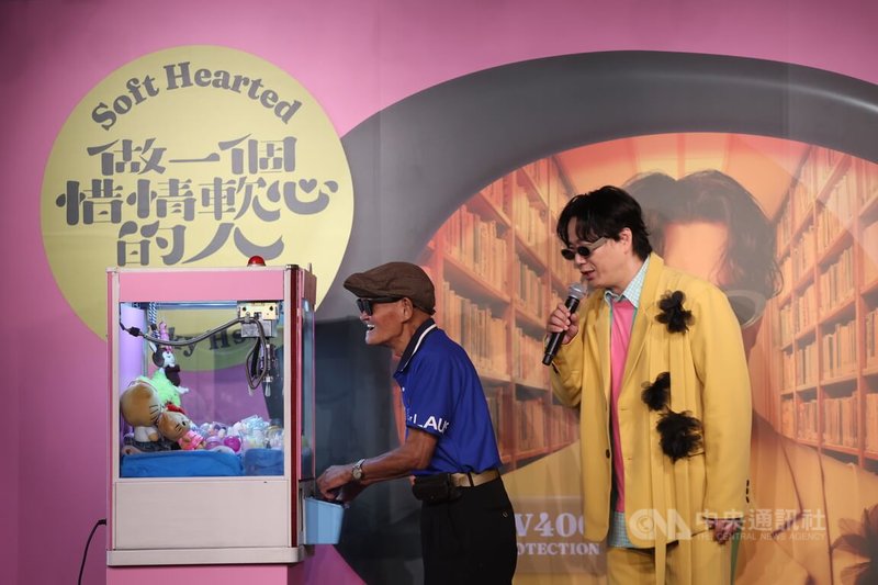 金曲歌王蕭煌奇(右)推出全新台語專輯「做一個惜情軟心的人」,21日下午在台北舉行專輯搶聽會,會中特別設置夾娃娃機台,蕭煌奇幽默帶領盲人歌手李炳輝(左)操作。中央社記者王飛華攝 114年8月21日