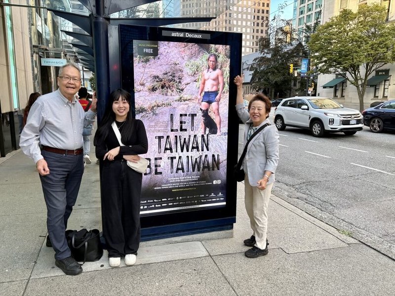 行政院顧問張理瑲(右)和夫婿潘立中(左)很開心和街頭上的「Let Taiwan Be Taiwan」燈箱廣告合影,一名來自日本的年輕女孩(中)還主動加入他們的行列,稱她非常喜觀台灣。(張理瑲提供)中央社記者程愛芬溫哥華傳真 114年8月22日