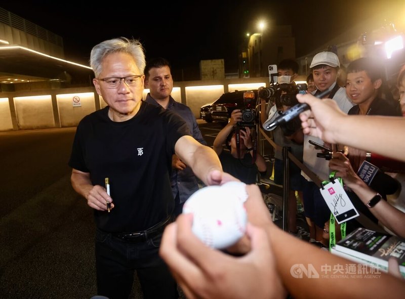 輝達(NVIDIA)執行長黃仁勳(左)22日搭乘專機快閃訪台,晚間搭機離台前,親切為前來送機的粉絲簽名留念。中央社記者張皓安攝 114年8月22日