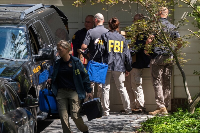 FBI探員22日將袋子和盒子從前白宮國安顧問波頓家中搬出。(美聯社)