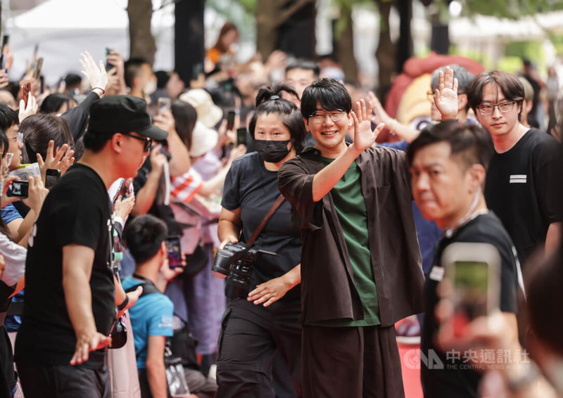 為日本超人氣動畫「鬼滅之刃」主角竈門炭治郎配音的聲優花江夏樹(中右綠衣者)應邀來台,23日在台北出席劇場版宣傳記者會,進場時開心與粉絲揮手致意。中央社記者裴禛攝 114年8月23日