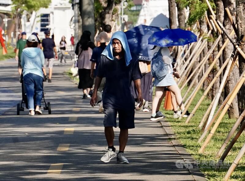 圖為駁二藝術特區周邊有民眾以毛巾蓋頭防曬、遮擋豔陽。（中央社檔案照片）