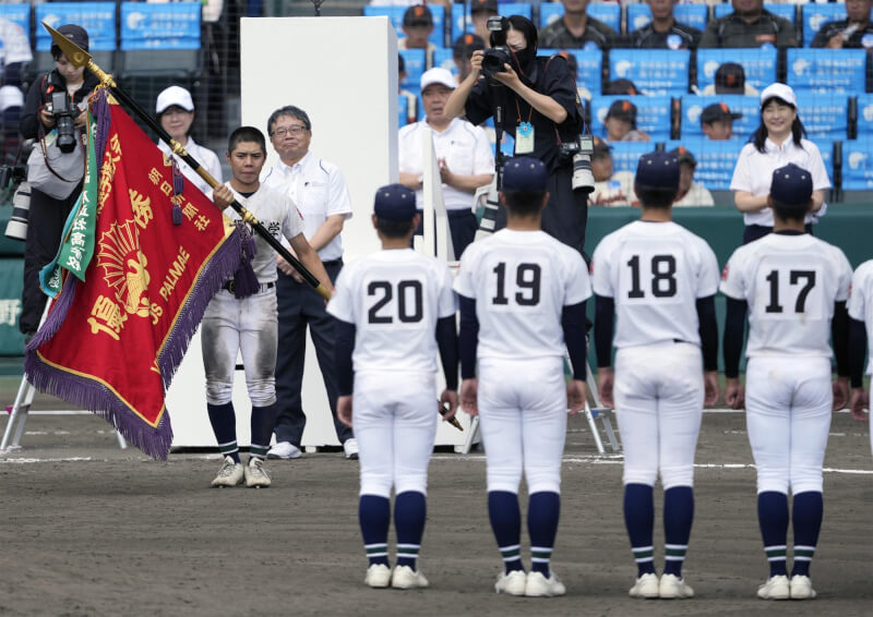 沖繩尚學隊長真喜志拓斗接過冠軍旗。(共同社)