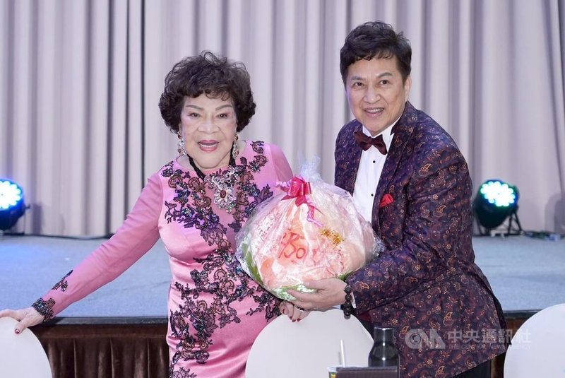 資深藝人周遊(阿姑)(左)24日歡慶88歲,開心和導演老公李朝永(右)拿壽桃合影。中央社記者洪素津攝 114年8月25日