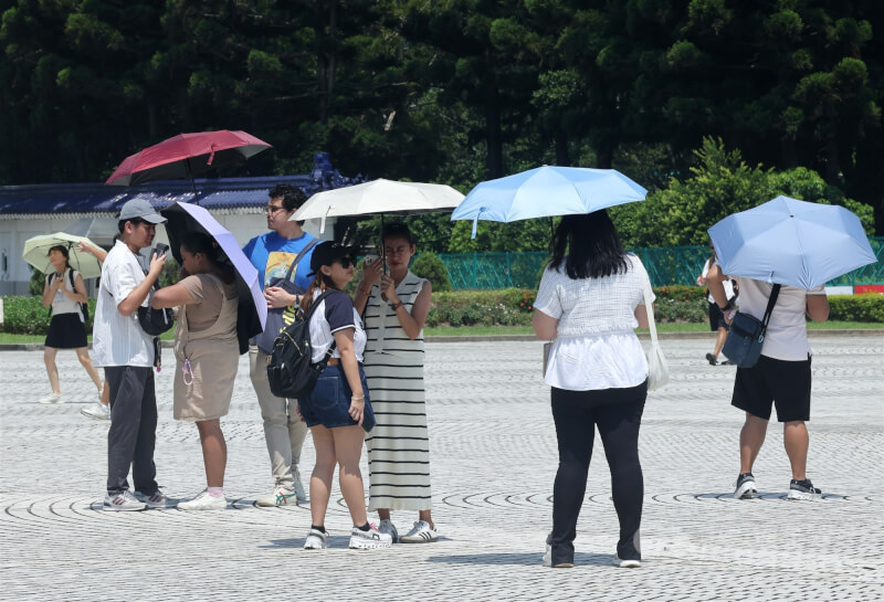圖為民眾出遊到台北市中正紀念堂,撐傘避免太陽直接照射。(中央社檔案照片)