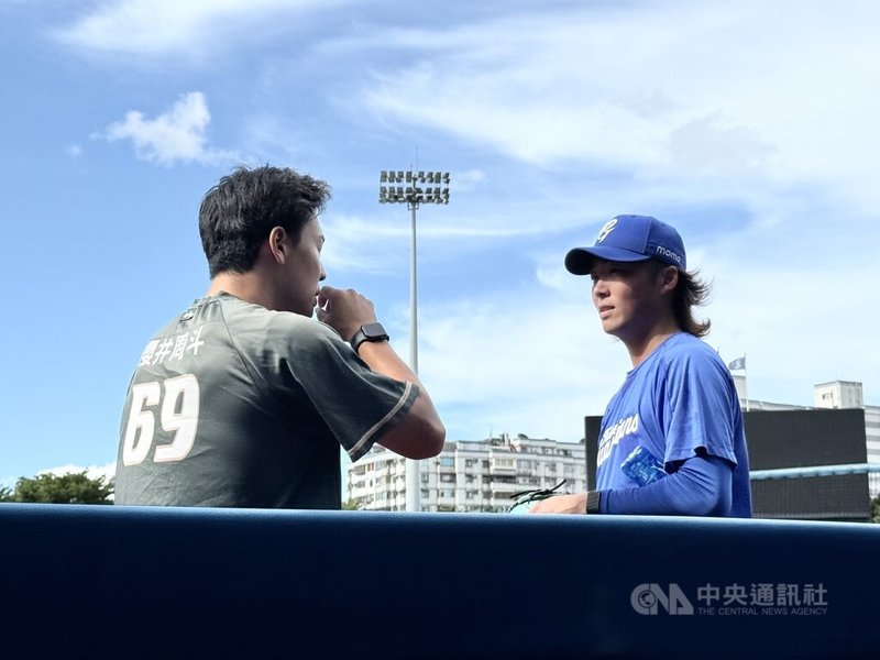 中華職棒富邦悍將日籍投手鈴木駿輔(右)27日獲得一軍先發出賽的機會,對手是台鋼雄鷹,26日賽前也與雄鷹隊日籍投手櫻井周斗(左)交談。中央社記者謝靜雯攝 114年8月26日