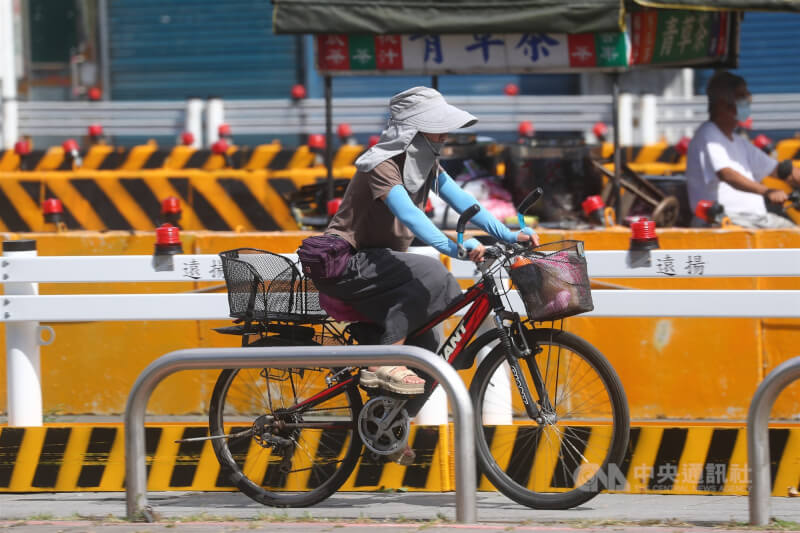 天氣高溫炎熱，新北市土城區街頭26日有單車騎士加強防曬措施，全身包緊緊。中央社記者王騰毅攝  114年8月26日