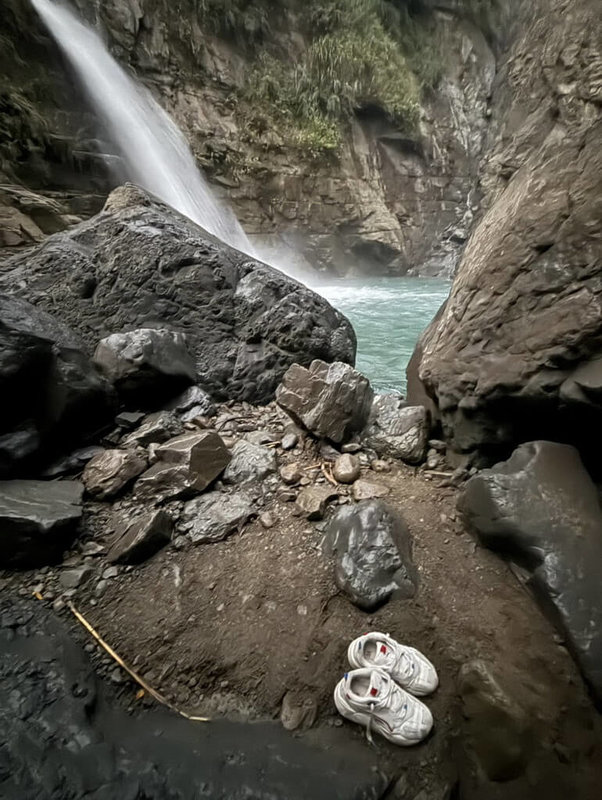 南華大學印度籍一男學生，25日疑在雲林古坑樟湖吊橋附近落水失蹤，至今搜救無果，現場發現一雙鞋子，疑似失蹤學生所有。（雲林縣消防局提供）中央社記者蔡智明傳真   114年8月26日