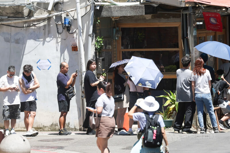 圖為北市中山區民眾在豔陽下排隊等候用餐。(中央社檔案照片)