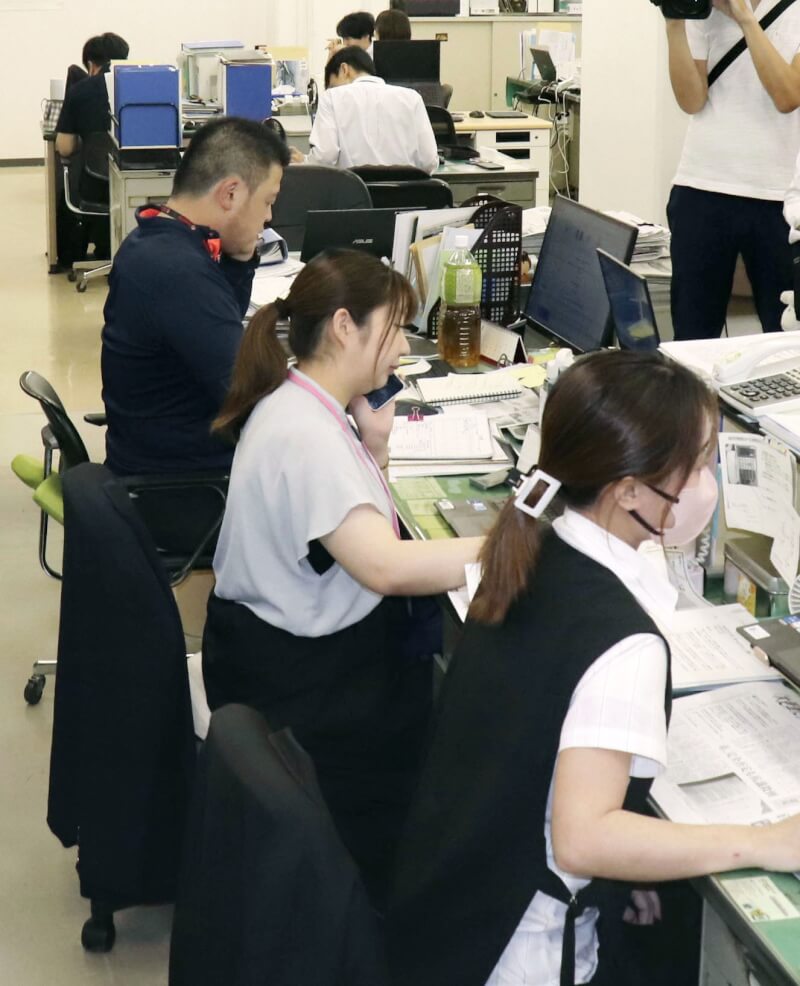 日本木更津市政府員工26日忙碌接聽電話。（共同社）