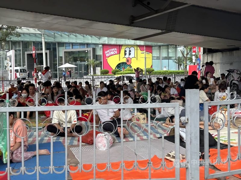 越南國慶前夕,29日下午兩點,路邊開始出現塑膠小椅凳、鋪平的紙箱,天橋下人潮席地而坐,慢慢聚集,為的就是等待隔天一早即將路過的大閱兵預演。中央社記者曾婷瑄河內攝 114年8月31日
