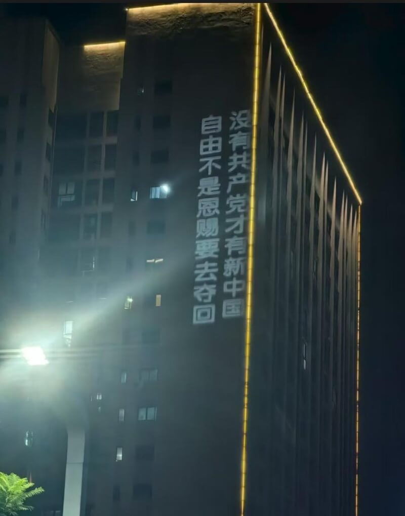 社群媒體X平台「李老師不是你老師」貼文,中國重慶大學城29日晚間有人以投影方式在一棟大樓外牆打出「推翻中共」的標語,時長逾50分鐘,引發海內外熱議。(圖取自x.com/whyyoutouzhele)