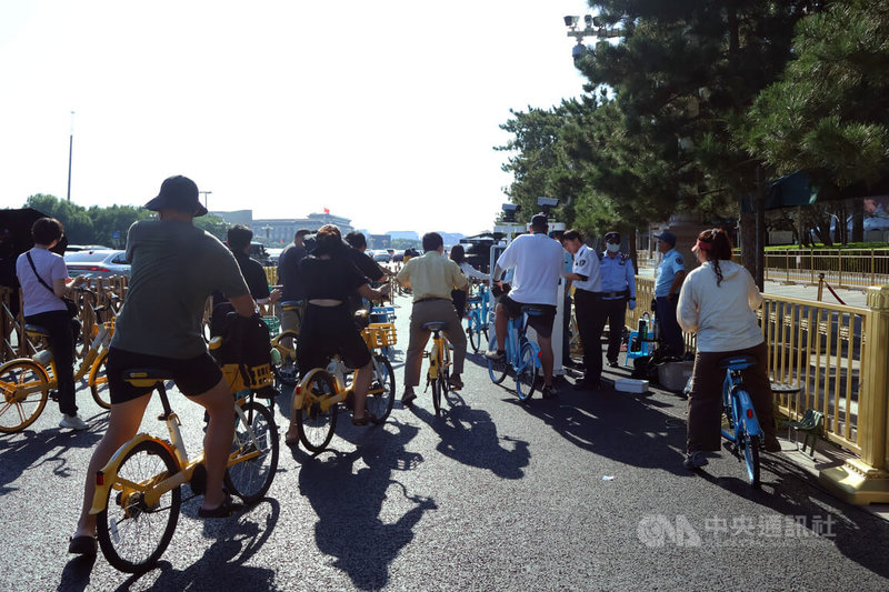 中共閱兵將在3日登場,這幾天有不少民眾騎著腳踏車行經長安街感受閱兵氣氛。圖為民眾在進入長安街前,得先讓工作人員查證件、打開背包檢查。中央社記者謝怡璇北京攝 114年9月1日