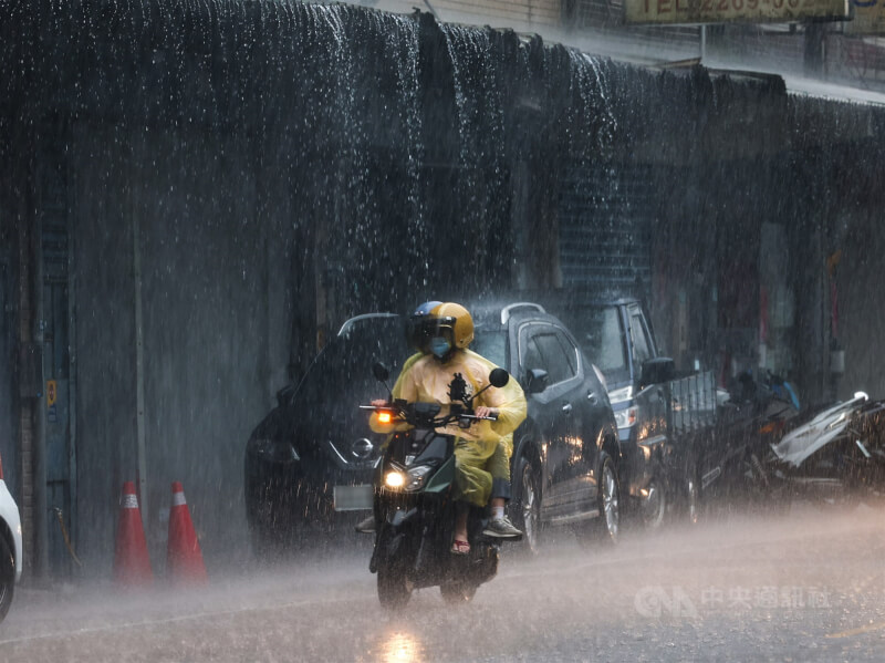 圖為新北市土城區午後下起雷陣雨,短時間降下的大量雨水沿著屋簷形成一道道雨瀑。(中央社檔案照片)