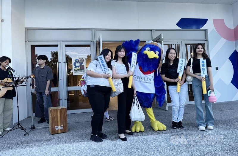 弘光科技大學在8日開學日舉辦「開學升級祝福」活動,學生拿著抽中的祝福和吉祥物合影。中央社記者趙麗妍攝 114年9月8日