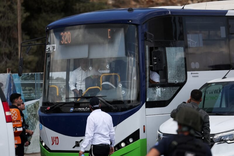 以色列耶路撒冷北部1處繁忙路口8日發生槍擊案，現場一輛公車擋風玻璃上可見彈孔。（路透社）