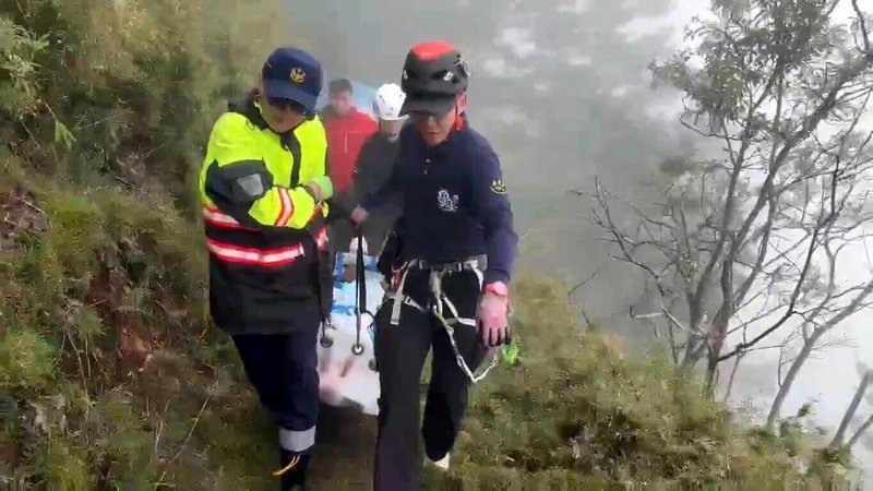 6旬吳姓女子7日跟團至玉山附近步道健行,中途不慎踩空滑落10米深邊坡,因無法行走求援,嘉義縣搜救人員以人力搬運方式救援。(警方提供)中央社記者黃國芳傳真 114年9月8日