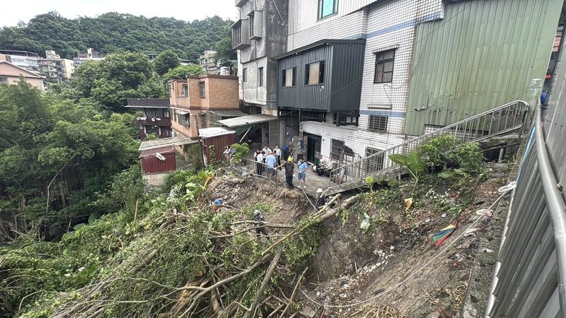 基隆市崇德路民宅後院邊坡因日前強降雨造成巨樹倒塌，壓住安樂國小沉砂池，且在雨水沖刷下形成陡峭邊坡，安樂區公所已緊急調派廠商進駐處理，最快可於10日完成。（讀者提供）中央社記者王朝鈺傳真  114年9月9日