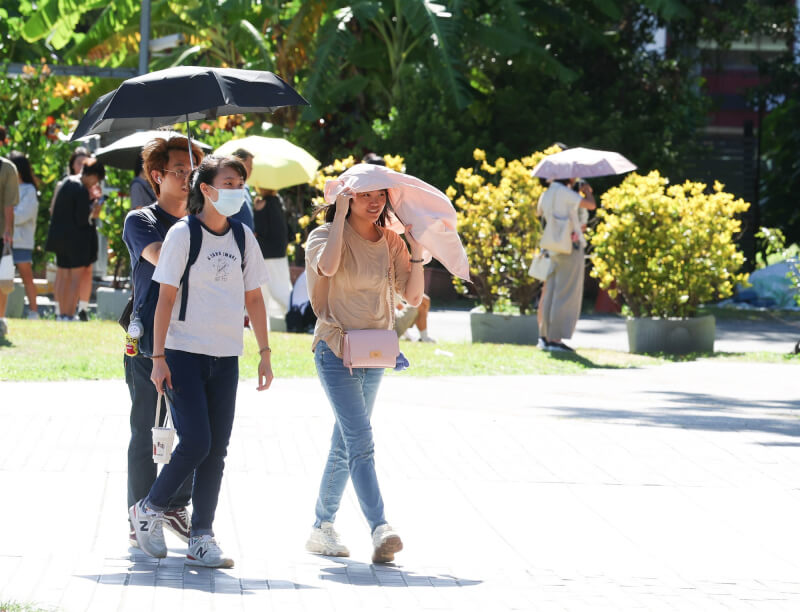 圖為6日北市華山文創園區出遊民眾以陽傘、隨身衣物遮擋豔陽。(中央社檔案照片)