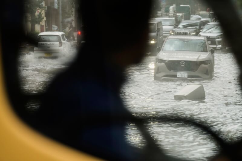 日本關東地區11日降下暴雨，東京都出現超過每小時100毫米的猛烈降雨，東京街頭可見淹水災情。（美聯社）