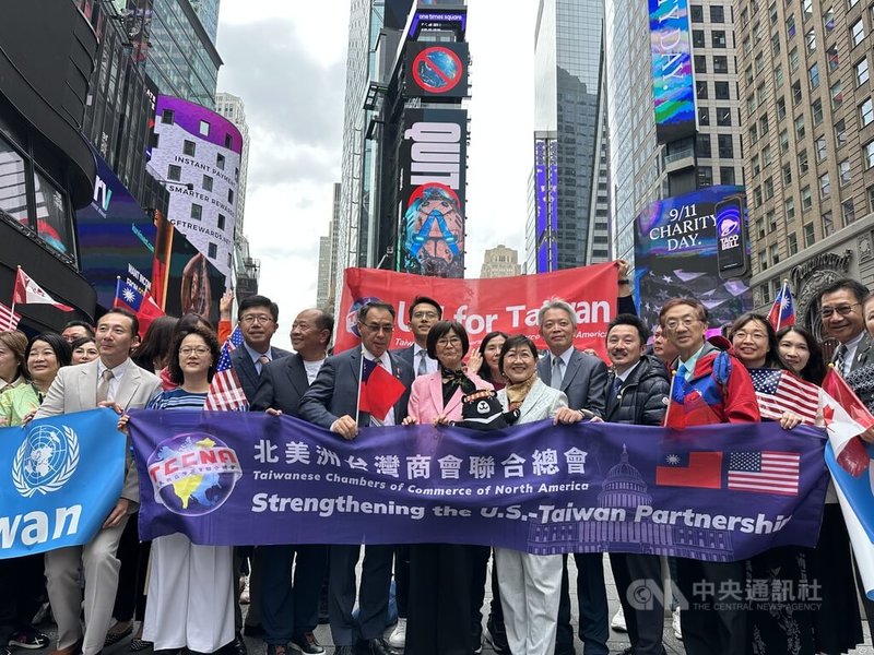 北美洲台商團體集資,9日起在紐約時報廣場大型螢幕看板播映台灣參與聯合國廣告,一行人在現場揮舞國旗。中央社記者廖漢原紐約攝 114年9月11日