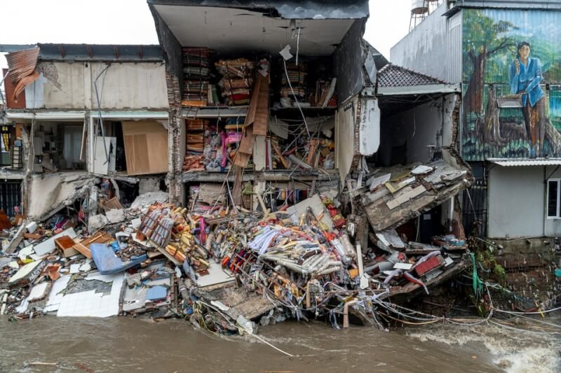 印尼峇里島豪雨成災，一家商店受洪水淹沒倒塌，店內貨物散落出來。（路透社）