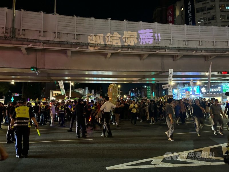台北公館圓環即將拆除並填平公車專用地下道，行人零死亡推動聯盟等團體12日晚間號召群眾繞行圓環表達反對立場，過程中人群一度走上車道。中央社記者陳昱婷攝　114年9月12日